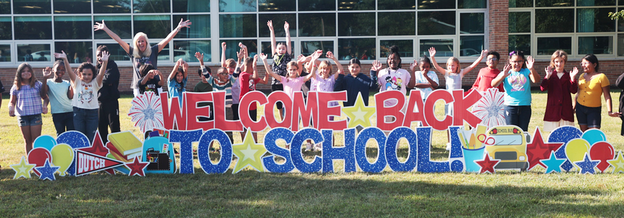 Students by Welcome back to School sign