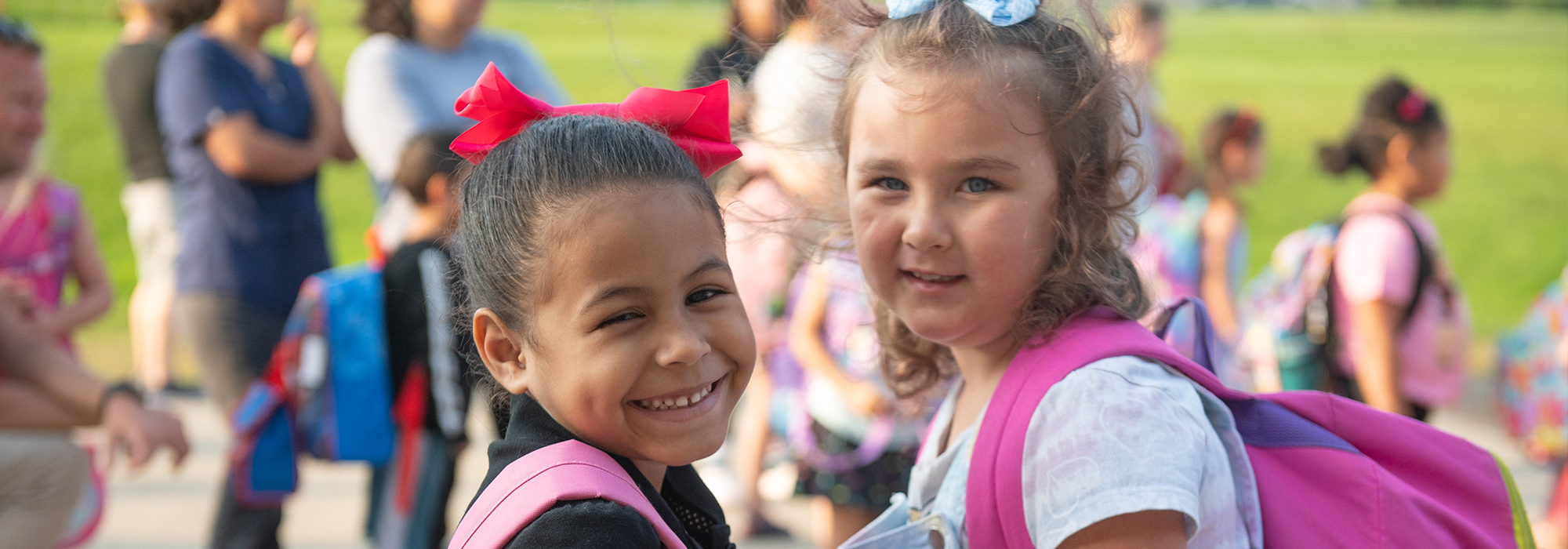Two girls with backpacks on first day of school