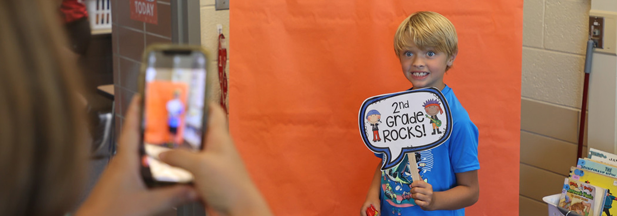 boy poses for pic with 2nd grade rocks sign